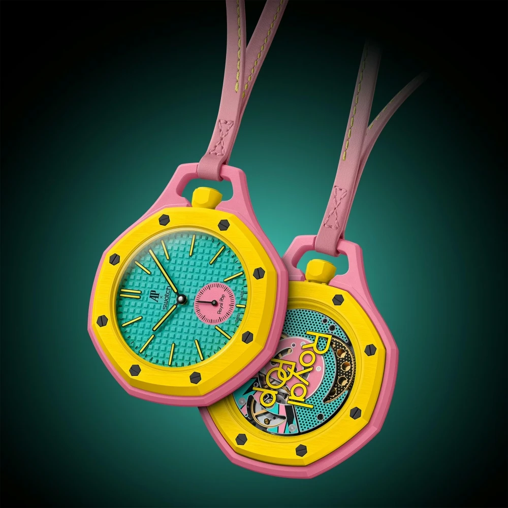 Audemars Piguet Swatch iş birliği Royal Pop cep saati koleksiyonundan, pembe kasalı, sarı çerçeveli ve turkuaz kadranlı iki renkli saat, biri ön yüzünü, diğeri mekanizması görünen arka yüzünü gösterirken pembe kayışlarıyla asılı duruyor.