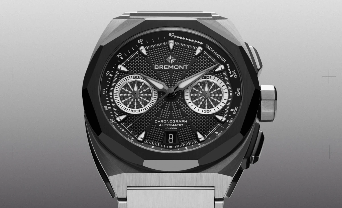 Bu yakın çekim görüntüde, fasetli siyah kasası, derin dokulu siyah kadranı, parlak ibreleri, iki kronograf alt kadranı ve takimetre ölçeği ile öne çıkan, Bremont Supernova Chronograph Automatic yazısı görünen, Ay'daki saat temasını yansıtan modern ve dayanıklı bir kol saati sergileniyor.