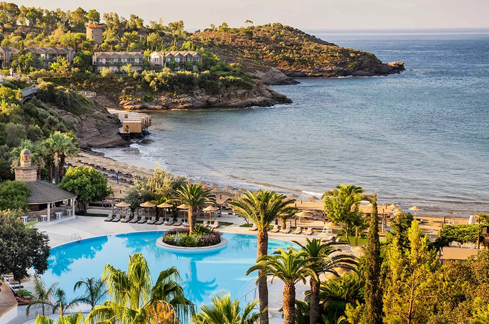 Club Marvy'nin yemyeşil tepelere kurulu otel binaları, tepede yer alan geleneksel rüzgar gülü, palmiye ağaçlarıyla çevrili büyük havuz, Ege Denizi'ne uzanan altın rengi plajı ve sayısız şezlong ile rahatlatıcı bir tatil atmosferi sunuyor.