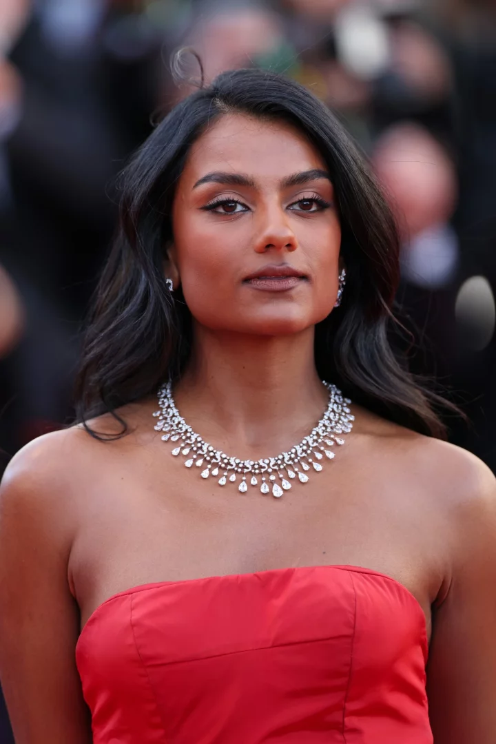 Simone Ashley, straplez kırmızı elbisesiyle Cannes kırmızı halısında, gerdanını süsleyen çok sıralı ve damla kesim pırlantalarla bezenmiş göz alıcı Messika mücevherleriyle adeta ışık saçan bir zarafet sergiliyor.