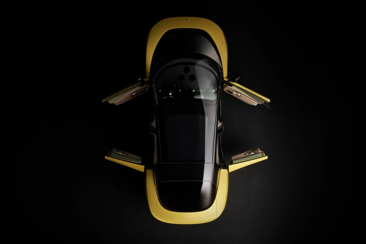 Siyah bir arka plan üzerinde, şık ve modern tasarımlı, sarı renkteki gövdesi ve siyah tavanıyla dikkat çeken Ferrari Luce model otomobil, dört adet ters yöne açılan kapıları ile yukarıdan geniş açılı bir kadrajda sergileniyor.