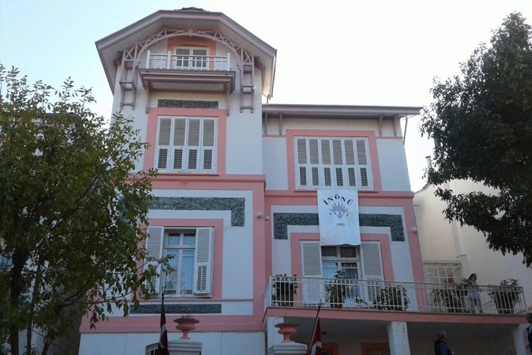 Beyaz ve pembe tonlarındaki dış cephesi, kapalı beyaz panjurlu pencereleri ve üst katlarındaki dekoratif ahşap detaylarıyla Heybeliada İsmet İnönü Müzesi'nin görkemli binası, bir pencereden sarkan İnönü Vakfı 1983 yazılı pankartıyla tanınıyor.