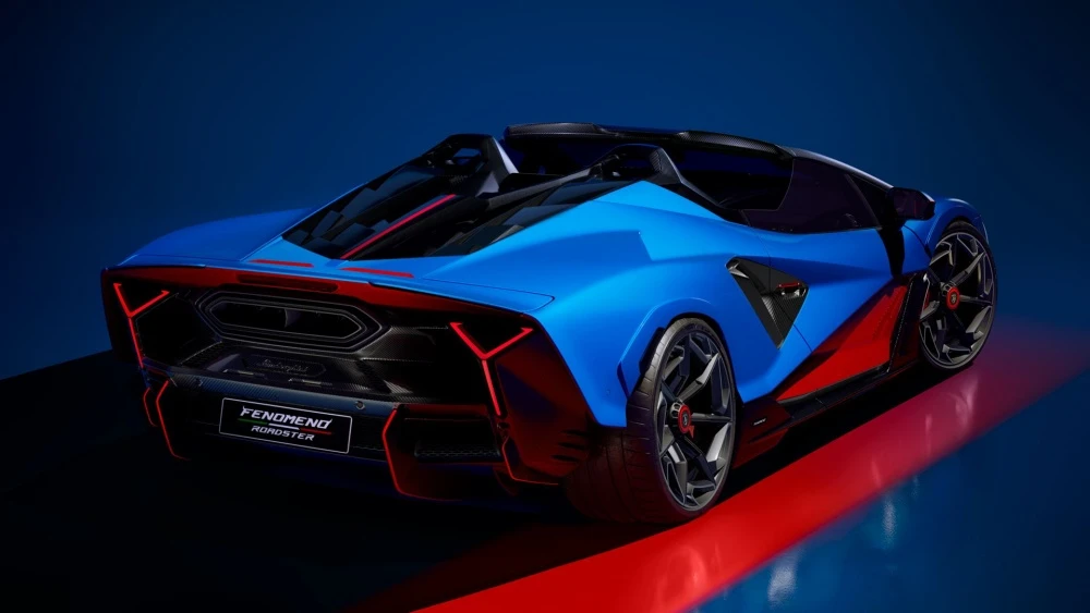 Mavi ve kırmızı renklerin hakim olduğu Lamborghini Fenomeno Roadster'ın dinamik arka tasarımı, parlak kırmızı açılı stop lambaları, sürücü koltuğunun üzerindeki açık kokpit ve belirgin karbon difüzörle güçlü ve fütüristik bir duruş sergiliyor.