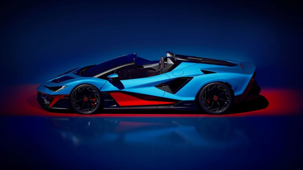 Parlak mavi ve kırmızı tonlarında, aerodinamik ve agresif çizgileriyle dikkat çeken Lamborghini Fenomeno Roadster'ın dramatik ışıklandırmanın vurguladığı şık yan profil tasarımı, en hızlı Lamborghini roadster modellerinden birini gözler önüne seriyor.