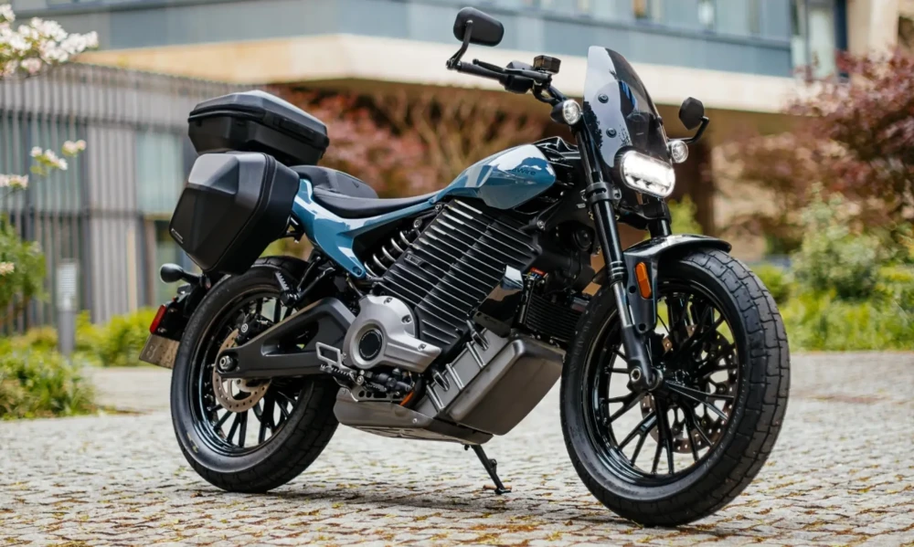 Mavimsi yeşil renkteki LiveWire S2 Del Mar elektrikli motosiklet, rüzgar korumalı ön camı ve pratik yan/arka çantalarıyla hem şehir içi çevikliği hem de uzun yol konforunu birleştiren iddialı bir premium elektrikli motosiklet olarak park edilmiş durumda.
