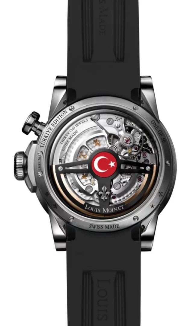 Bir Louis Moinet Memoris Türkiye Edition saatinin şeffaf arka kapağını gösteren yakın çekim görüntüde, karmaşık otomatik iskelet mekanizmasının ortasında ay yıldızlı Türk bayrağı detayı dikkat çekiyor, saatin sınırlı üretim olduğunu ve ustaca İsviçre işçiliğini vurgulayan detaylar çevresinde yazılı.