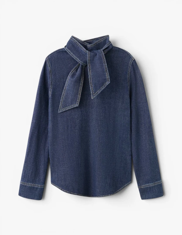 Marka Adı: Mango
Ürün Adı: Mango Kadın Denim Gömlek Fular Yakalı
Ürün Cinsiyeti: Kadın
Ürün Tipi: Gömlek
Ürün Sezonsallığı: Dört Mevsimlik
Ürün Çeşidi: Denim Gömlek
Ürün Özellikleri: Koyu indigo renkli, hafif denim kumaştan üretilmiş bu uzun kollu gömlek, boynundaki zarif fular detayıyla öne çıkıyor. Fular, aynı denim kumaş ve belirgin dikiş detaylarıyla tasarlanmış olup, bağcık şeklinde bağlanmıştır. Kumaşın tüm kenarlarında, özellikle yaka, manşetler ve fular üzerinde açık renkli (krem/beyaz) kontrast dikişler bulunmaktadır. Uzun kollu tasarımı, klasik kesimi ve alt kısmındaki kavisli bitişi ile rahat bir kullanım sunar.
Öne Çıkan Detaylar:
- Fular şeklinde bağlanabilen yaka detayı
- Koyu denim üzerinde kontrast açık renk dikişler
- Uzun kollu ve kavisli etek ucu
Kimler Kullanıyor?: Zamansız parçaları gardırobuna eklemeyi seven, rahatlığı ve şıklığı bir arada arayan herkes bu gömleği tercih edebilir. Klasik denim dokusunu modern bir fular yaka detayıyla birleştiren bu tasarım, hem günlük kombinlerde hem de daha özel anlarda zahmetsiz bir zarafet sunuyor. Şehir hayatının dinamizmine ayak uydururken, stilinde özgün ve sofistike bir dokunuş arayan kişilerin beğenisini kazanacaktır.