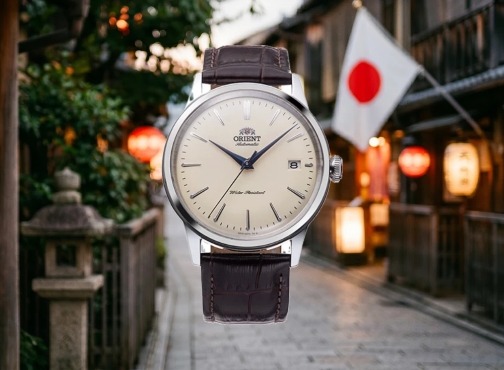 Geleneksel Japon sokaklarının bulanık fonunda, Japon bayrağı ve kırmızı fenerler eşliğinde, Orient Bambino otomatik erkek saati; krem kadranı, kahverengi timsah derisi desenli kordonu ve parlayan gümüş kasasıyla zarif bir dress watch olarak öne çıkıyor.