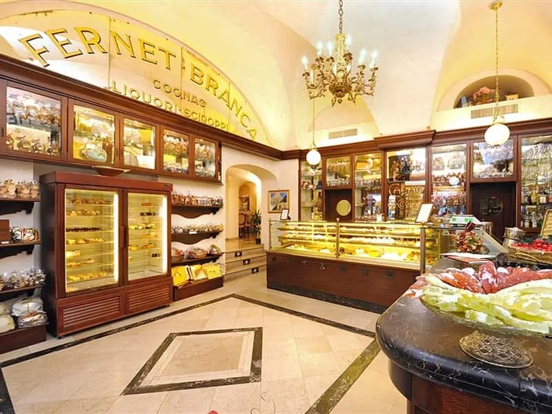 Zengin ahşap vitrinler, raflardaki rengarenk tatlı ve şekerlemeler, mermer desenli zemini ve tavandaki şamdanıyla eski bir İtalyan pastanesini andıran Pansa Pastanesi'nin iç mekanında, kemerli bir duvarda FERNET BRANCA yazılı bir tabela dikkat çekiyor.