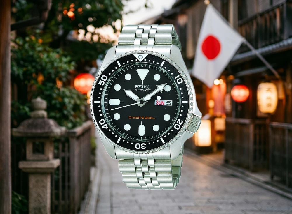 Geleneksel Japon binalarının ve dalgalanan Japon bayrağının yer aldığı bulanık bir sokak manzarasının önünde, siyah kadranında DIVER'S 200m yazan parlak metal kordonlu bir Seiko otomatik Japon dalış saati yakın çekimde sergileniyor.