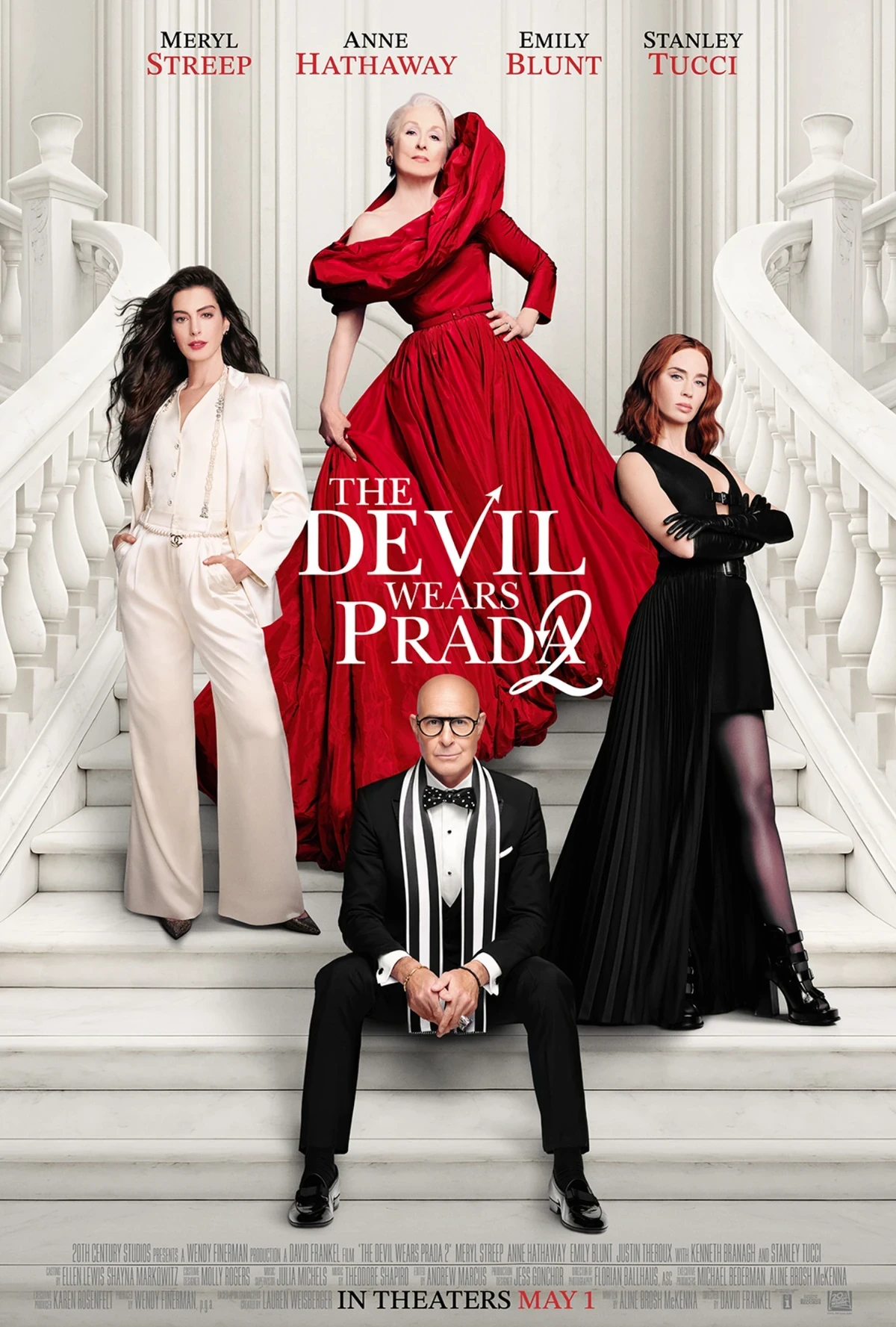Şeytan Marka Giyer 2 filminin resmi oyuncu kadrosunu sergileyen bu şık merdiven afişinde, Meryl Streep kırmızı gösterişli bir elbise, Anne Hathaway krem renkli zarif bir pantolon takımı, Emily Blunt siyah pilili bir elbise ve Stanley Tucci smokin giyerek beyaz bir merdivende dramatik pozlar veriyor, filmin lüks ve moda dolu dünyasını vurguluyor.