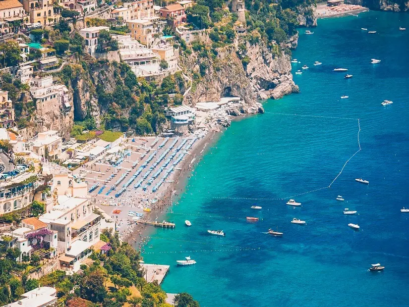 Spiaggia Grande plajının ve ona yaslanmış pitoresk sahil kasabasının kuşbakışı görüntüsünde, yamaçlara sıkışmış çok katlı renkli binalar, turkuaz renkteki Akdeniz'in kıyısında mavi şemsiyelerle dolu bir kumsal ve açık denizde yüzen tekneler huzurlu bir yaz gününü gözler önüne seriyor.