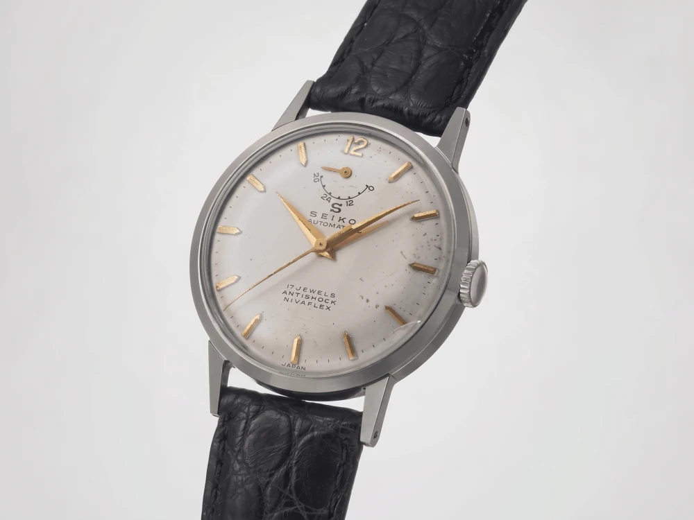 Tarihteki ilk Seiko kol saati olarak bilinen bu model, üzerinde belirgin bir patina ve hafif lekelenmeler olan açık renk kadranında altın rengi baton indeksler, 12 konumunda 24/12 göstergeli bir güç rezervi alt kadranı, SEIKO AUTOMATIC, 17 JEWELS, ANTISHOCK, NIVAFLEX yazıları ve klasik siyah timsah derisi desenli kordonuyla gümüş rengi bir kasaya sahip.