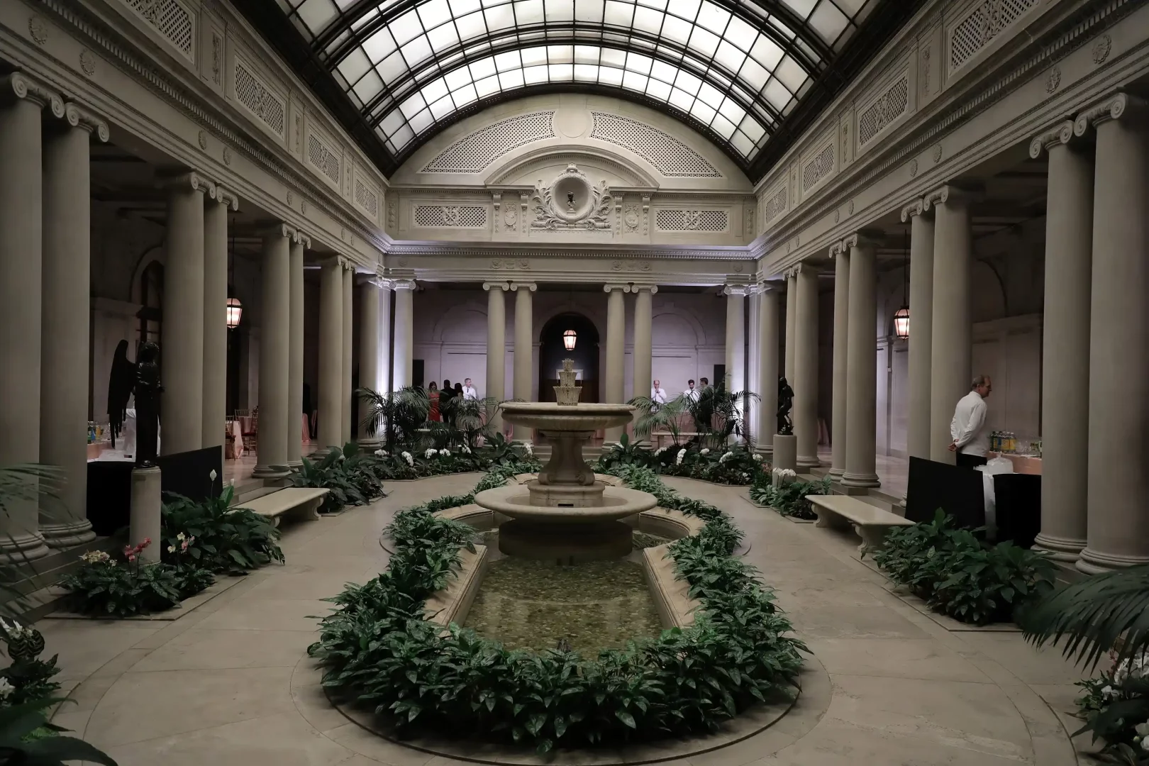 The Frick Collection'ın uzun sütunlarla çevrili, ortasında fıskiyeli havuz ve yeşil bitkilerle süslü, cam tavanlı zarif iç avlusu, Louis Vuitton Cruise 2027 defilesi için özel olarak hazırlanmış büyüleyici bir moda mekanı olarak gösteriliyor.