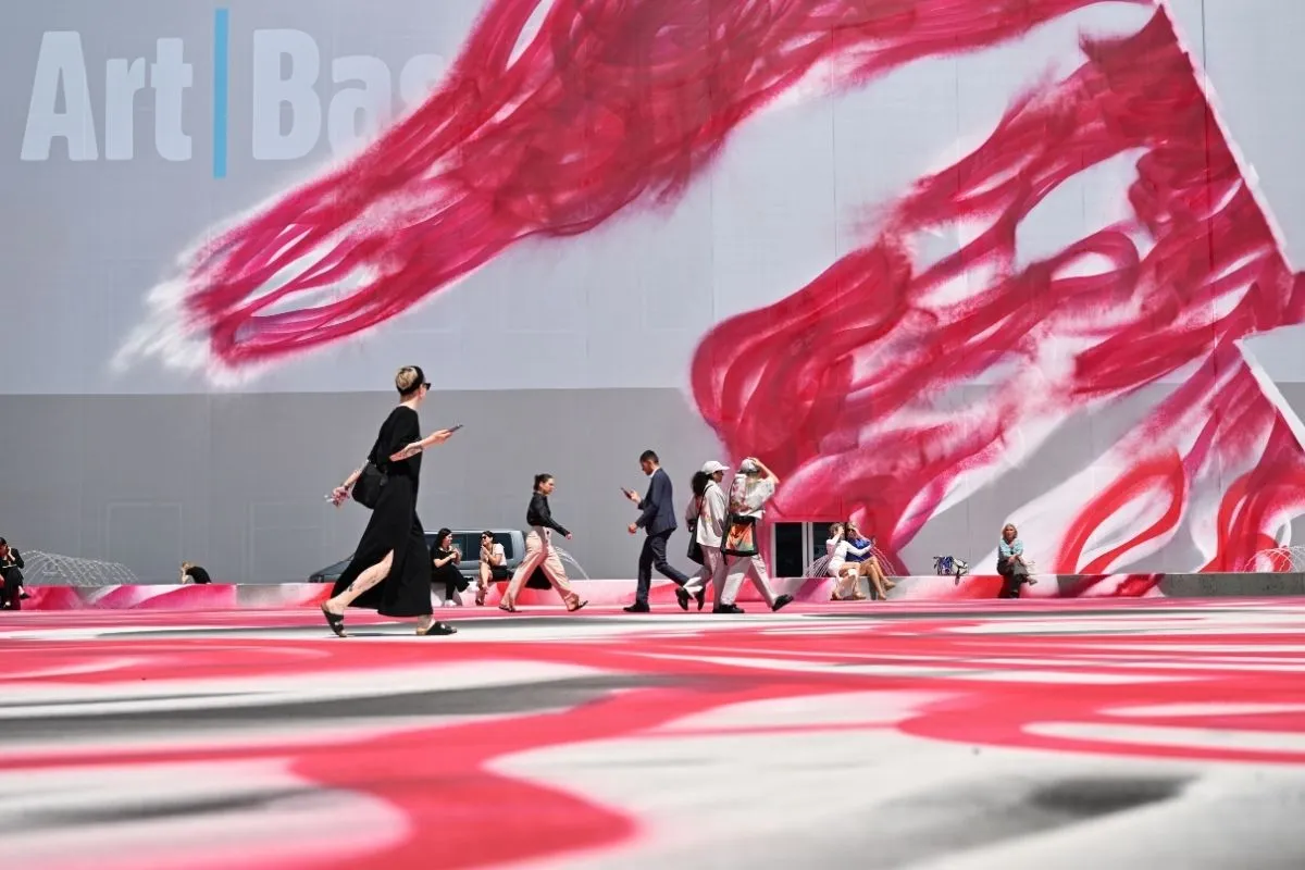 Art Basel fuar alanının dış cephesini ve zeminini kaplayan, dinamik pembe-kırmızı soyut bir enstalasyonun önünden geçen ziyaretçiler, bu kapsamlı rehberin keşfetmenizi sağlayacağı çağdaş sanat ortamının canlılığını gözler önüne seriyor.