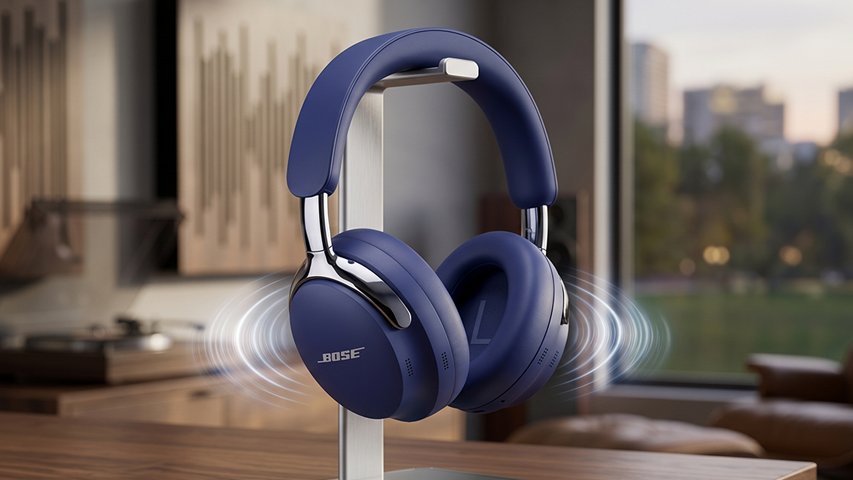 Koyu mavi renkli, parlak gümüş detaylarla zenginleştirilmiş Bose QuietComfort Ultra kulak üstü kulaklık, şık bir metal standda dururken etrafında yayılan dairesel dalgalarla üstün gürültü engelleme özelliğini ve zengin müzik deneyimini vurguluyor; bu tasarım, modern yaşamın ayrılmaz bir parçası olan en iyi kulaklık markaları rehberinde stil ve konforu birleştiren bir ürün olarak öne çıkıyor.