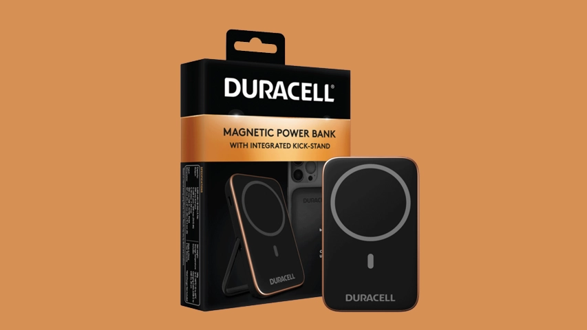 Turuncu arka plan üzerinde, Duracell markalı, siyah renkli ve kenarları bakır tonlu, entegre destek ayağına sahip, dairesel manyetik şarj alanıyla dikkat çeken 25W hızlı şarj özellikli bir manyetik güç bankası ve kutusu yan yana sergileniyor.