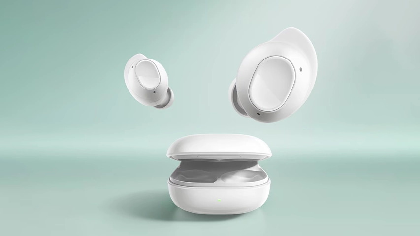 Açık ve yumuşak bir mint yeşili arka plan üzerinde, iki adet beyaz Galaxy Buds FE kablosuz kulaklık parçası, kapakları açık şarj kutusundan ayrılmış halde zarifçe havada süzülüyor; kutunun ön yüzeyindeki küçük yeşil şarj gösterge ışığı belirgin bir detay olarak öne çıkıyor.