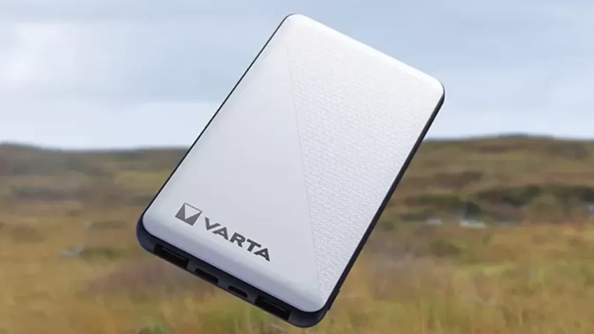 Yeni nesil taşınabilir enerji depolama çözümlerinden biri olan Varta Power Bank, ön yüzünde belirgin Varta logosu ve dokulu tasarımıyla dikkat çekiyor; cihazın alt kısmında birden fazla bağlantı noktası net bir şekilde görülürken, hafif eğimli duruşu bulanık bir dış mekan fonunda belirginleşiyor.