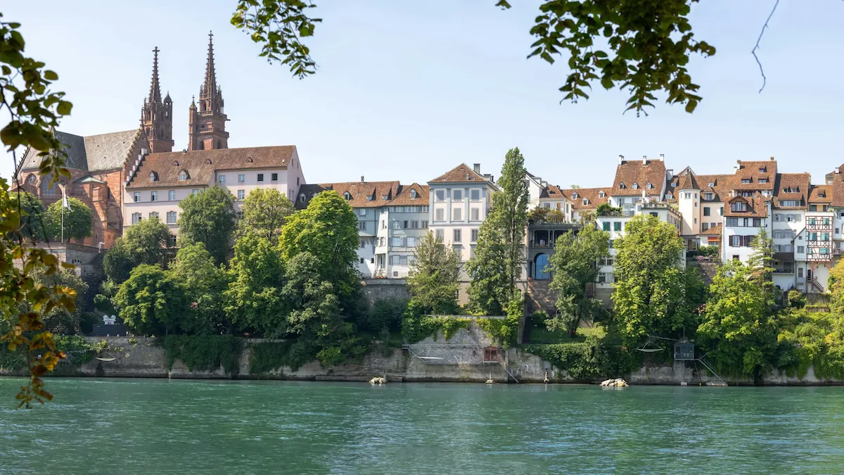 Ren Nehri'nin karşı kıyısından çekilmiş bu panoramik Basel manzarasında, yemyeşil ağaçlarla kaplı dik yamaçta yükselen tarihi binalar ve çift kuleli Basel Katedrali belirgin bir şekilde görülüyor. Bu büyüleyici şehir manzarası, Basel gezilecek yerler listesindeki güzellikleri gözler önüne seriyor.