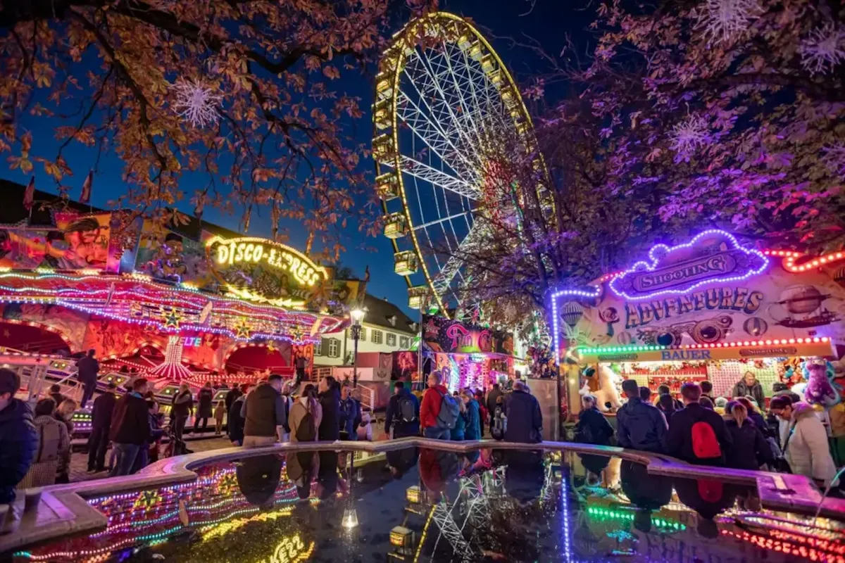Basel gezilecek yerler rotasında Basel Sonbahar Fuarı’nın gece ışıkları, dönme dolapları, lunapark alanları ve renkli festival atmosferi.