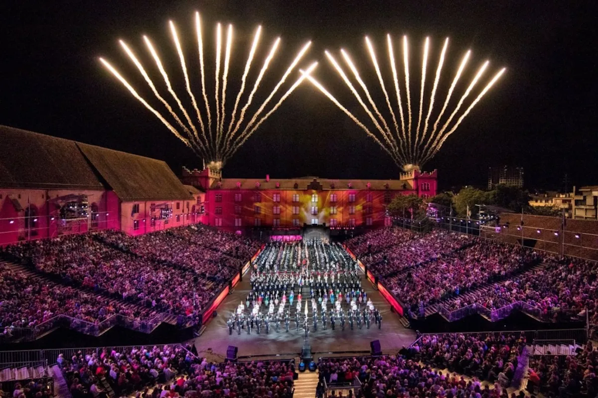 Basel gezilecek yerler arasında Basel Tattoo festivalinde bando performansı, tarihi sahne, ışık gösterileri ve kalabalık tribünler.
