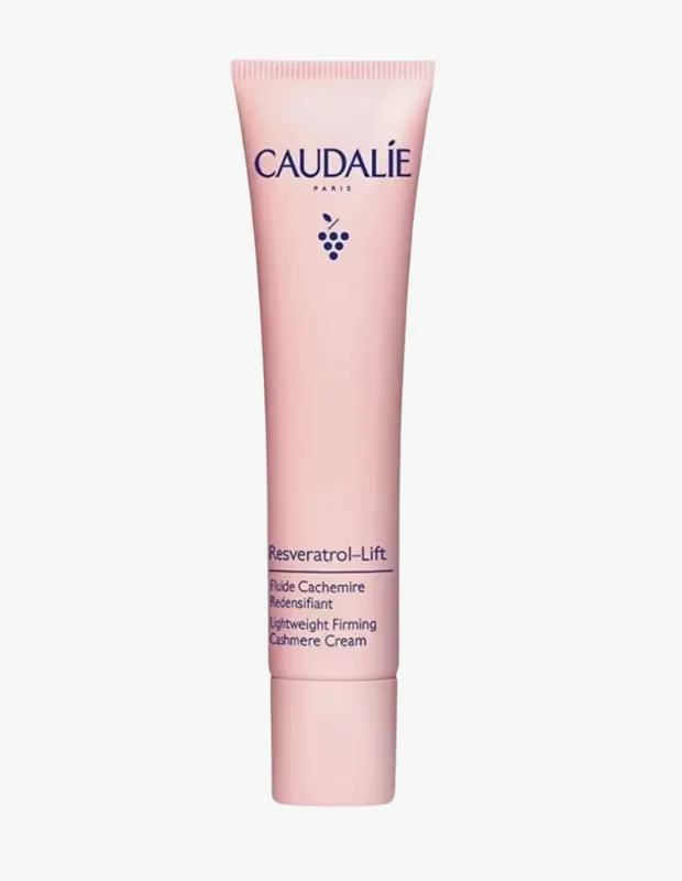 Açık pembe renkteki Caudalie Resveratrol-Lift Lightweight Firming Cashmere Cream tüpü, üzerinde markanın üzüm sembolüyle, Resveratrolün cilt yaşlanmasını hücresel düzeyde durdurma ve longevity faydalarına vurgu yapan yazıyla dikkat çekiyor.