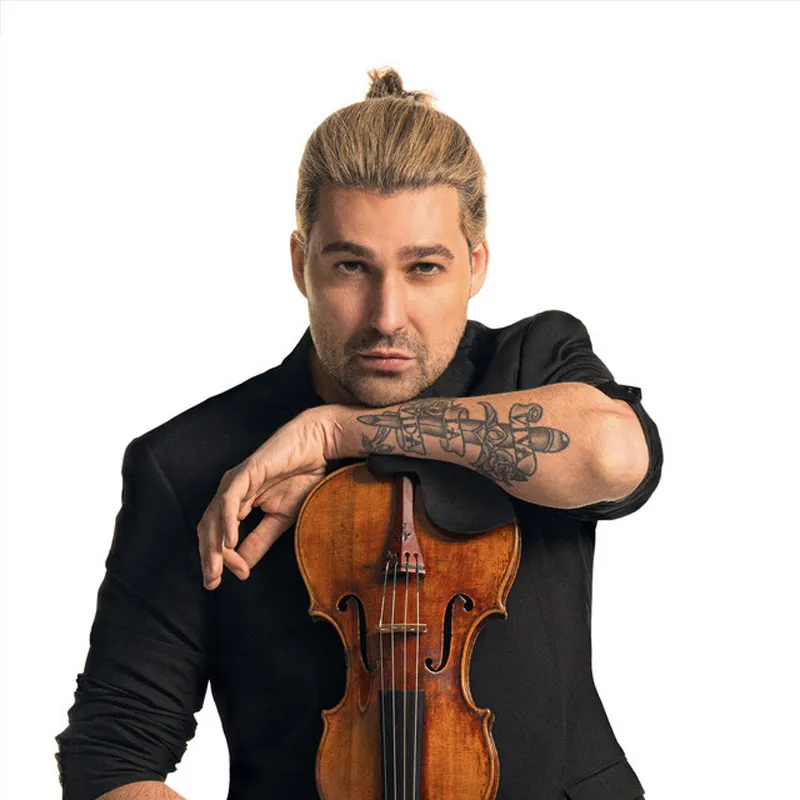 Klasik müzik ile pop ve rock dünyasını buluşturan crossover müziği temsilcisi David Garrett, sarı topuzlu saçları ve sol kolundaki dövmesiyle, siyah ceketi içinde kemanını tutarken doğrudan izleyiciye bakıyor.