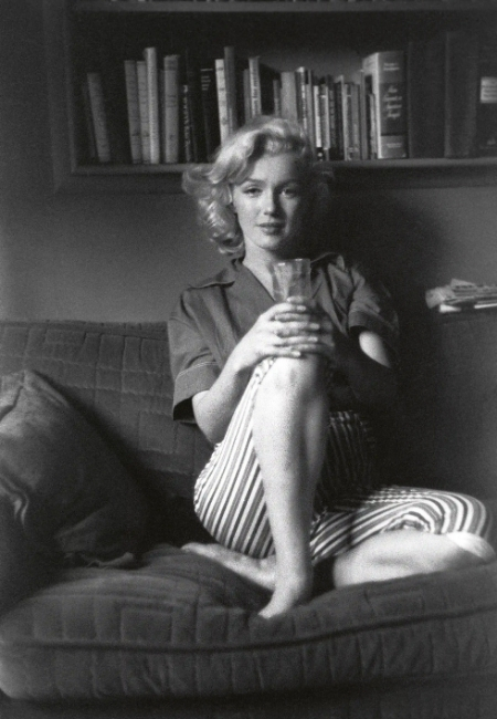 Siyah beyaz bir karede, kitaplık rafının önünde rahat bir koltukta bacak bacak üstüne atmış, elinde bir bardak tutan Marilyn Monroe'nun sıcak gülümsemesi ve doğal duruşu, Blancpain'in onun kişisel saatinden ilham alarak yarattığı Ladybird Tribute koleksiyonunun ardındaki zamansız zarafeti ve ikonik Hollywood efsanesinin kalıcı etkisini vurguluyor.