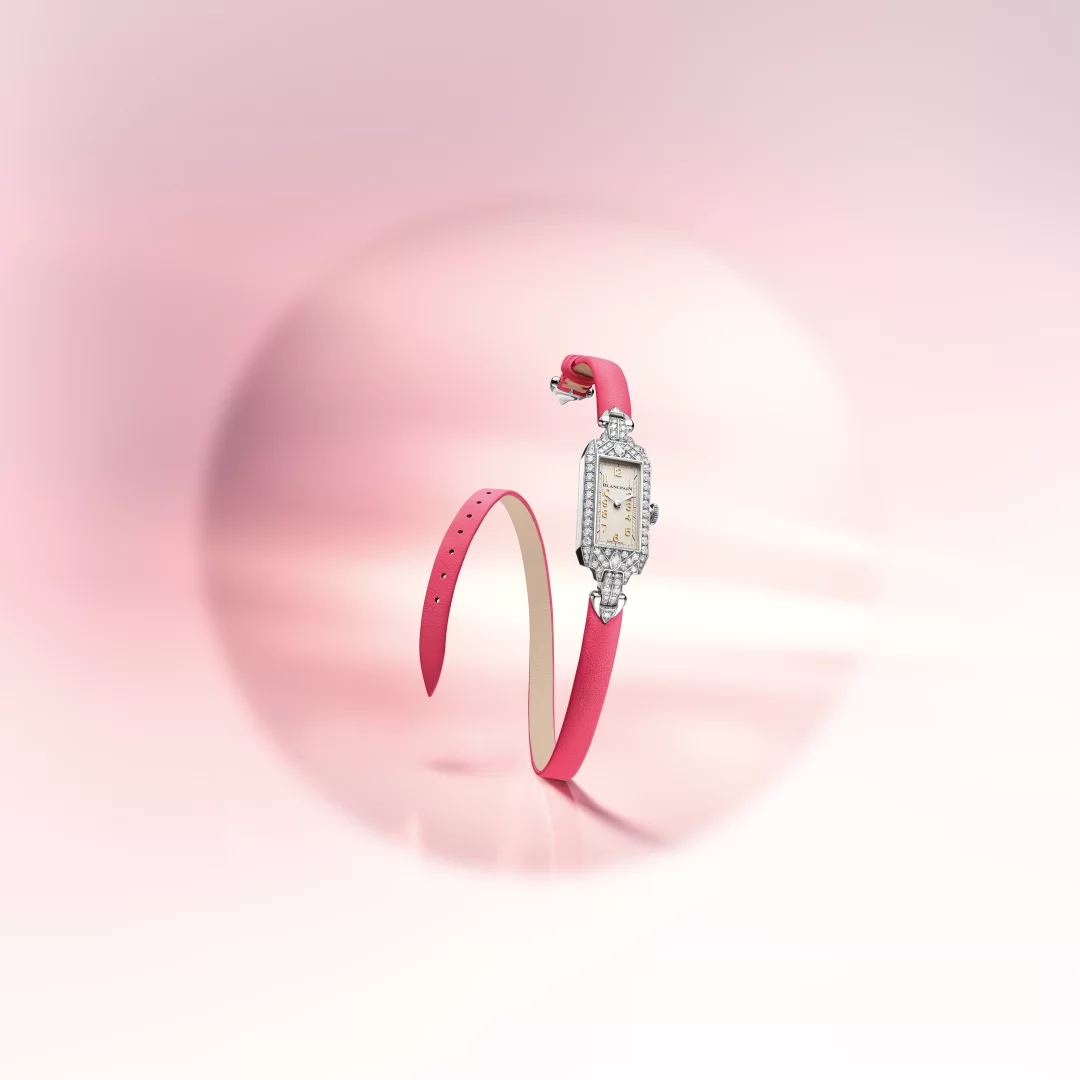 Blancpain'in Marilyn Monroe'nun saatinden ilham alarak tasarladığı Ladybird Tribute koleksiyonuna ait, pırlantalarla bezeli, Art Deco esintili dikdörtgen kasaya ve zarif bir krem kadranına sahip bu çarpıcı model, canlı pembe çift turlu deri kayışıyla rüya gibi pembe bir zeminde süzülüyor.