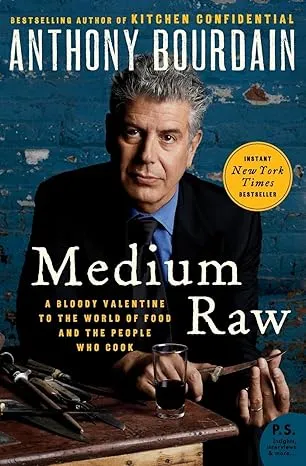 Anthony Bourdain'in Medium Raw adlı kitabının kapağında, gri saçlı, takım elbiseli yazar okuyucuya bakarken, önünde bir kadeh içki ve masa üzerinde çeşitli mutfak aletleri görülüyor, bu görüntü onun yemek dünyasındaki özgün yerini ve şef kişiliğini yansıtıyor.