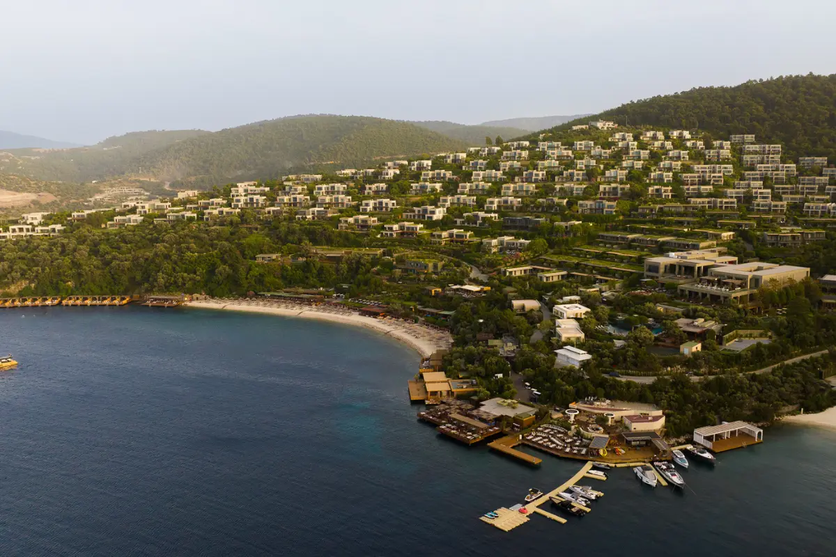 Cennet Koyu'nun eşsiz doğasına uyumlu modern mimarisiyle, yemyeşil yamaçlara serpiştirilmiş çok sayıda villası, geniş plajı ve iskeleleriyle deniz kenarında uzanan Mandarin Oriental, Bodrum, kapsamlı bir iyi yaşam deneyimi sunan lüks bir tesisi kuş bakışı gözler önüne seriyor.