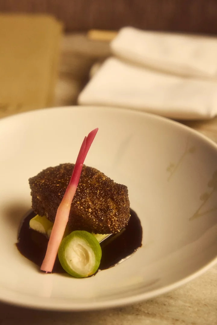 Beyaz tabakta servis edilen, koyu kahverengi, üzeri hafif pütürlü, dikdörtgen şekilli Sous Vide Shortribs, pembe-kırmızı renkli ince bir zencefil dilimi ve ortası beyaz, halka şeklinde yeşil bir garnitürle süslenmiş parlak, koyu renkli bir sosun üzerinde, Nobu Istanbul'un beşinci yılına özel menüsünden enfes bir sunumla iştah açıcı duruyor.