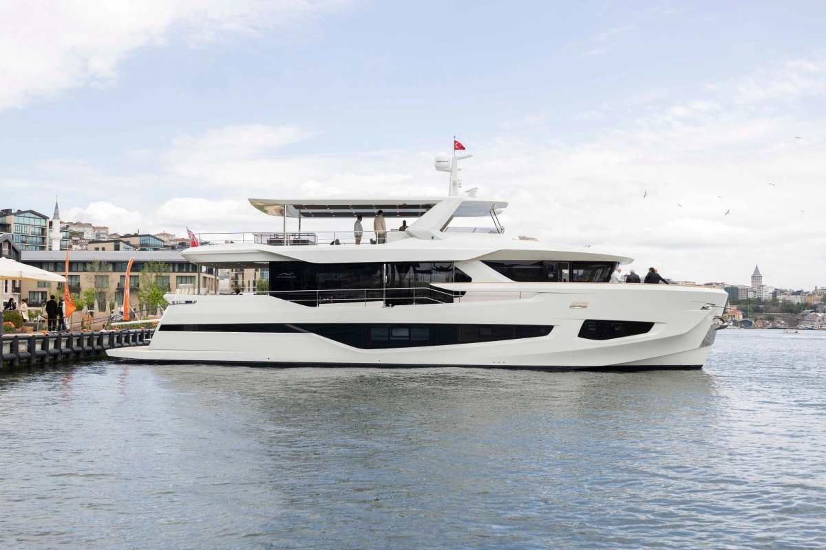 İstanbul'da bir iskeleye yanaşmış, modern dış tasarımına sahip, bembeyaz ve pürüzsüz hatlarıyla dikkat çeken Numarine 27XP Explorer yat, üzerinde Türk bayrağı dalgalanırken, arka planda Galata Kulesi ve tarihi şehir silüetiyle eşsiz bir manzara sunuyor.