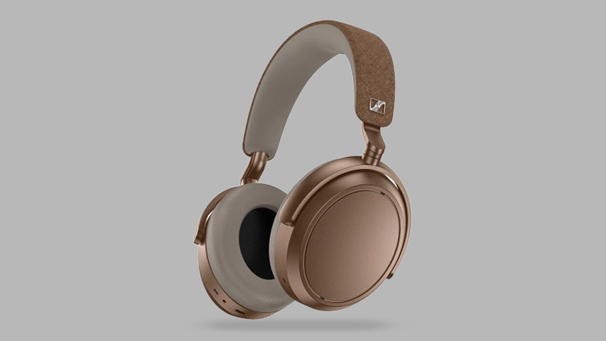Sennheiser Momentum 4 Wireless kulaklık, bakır tonlarında metalik kulaklık kapakları ve bej renkli yumuşak kulak yastıklarıyla, açık gri zeminde hafifçe havada dururken zarif kahverengi kumaş kaplı kafa bandı detaylarını sergiliyor.