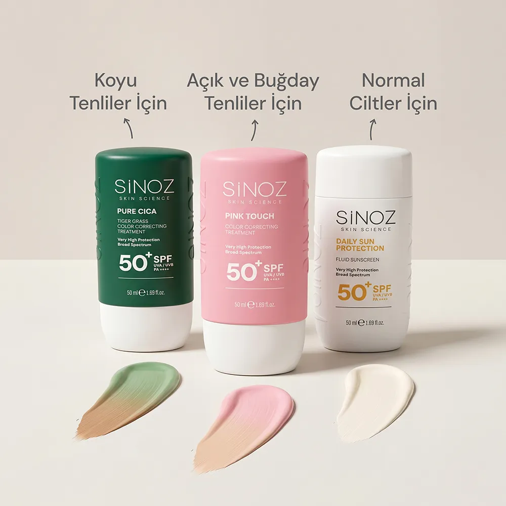 Üç farklı renk ve cilt tipine özel, yeşil, pembe ve beyaz ambalajlı Sinoz SPF 50+ güneş kremleri, koyu, açık-buğday ve normal ciltler için tasarlanmış farklı renk tonlarındaki krem örnekleriyle birlikte bir yüzeyde sergileniyor.