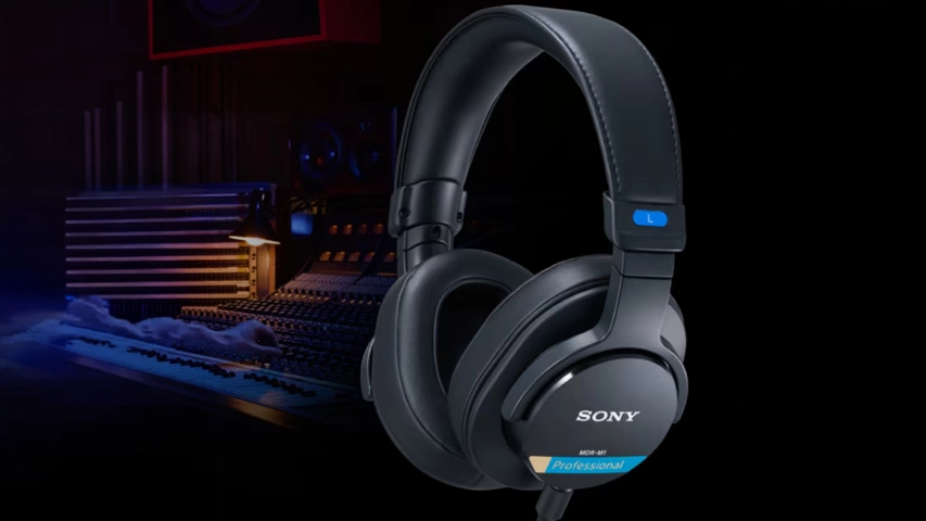Siyah renkteki Sony MDR-M1 Professional stüdyo kulaklığı, arka planda bulanık görünen bir ses mikseri ve diğer profesyonel ekipmanlarla dolu bir müzik stüdyosu ortamında sergilenerek yüksek kaliteli ses deneyimini vurguluyor.
