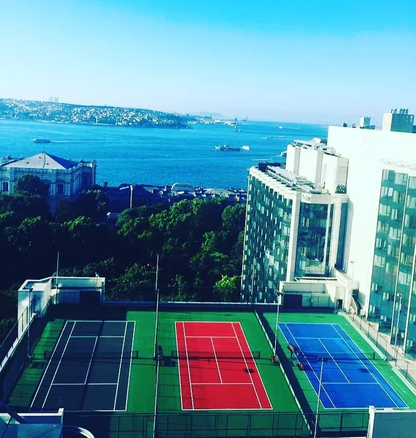 Swissôtel The Bosphorus'un çatısında yer alan, koyu yeşil, kırmızı ve mavi renklerdeki üç modern tenis kortu, arkasında masmavi Boğaz'ın hareketli gemileri ve İstanbul'un tarihi silüetiyle eşsiz bir manzara sunuyor.