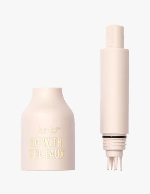 tarte markalı, açık bej rengindeki kirpik kaleminin GO WITH THE FAUX yazılı kapağı ve uzun, sivri uçlu fırçalı aplikatör kısmı beyaz fon üzerinde belirgin bir şekilde duruyor, ürünün takma kirpik görünümü sağlama özelliğini vurguluyor.