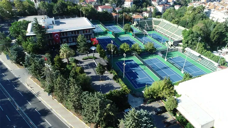 TED Spor Kulübü'nün yemyeşil ağaçlarla çevrili geniş arazisinde, mavi zeminli çok sayıda tenis kortunun ve Türk bayrağının dalgalandığı ana kulüp binasının kuşbakışı görüntüsü, bazı kortlarda tenis oynayan oyuncularla tesisin hareketliliğini ve kapasitesini gözler önüne seriyor.