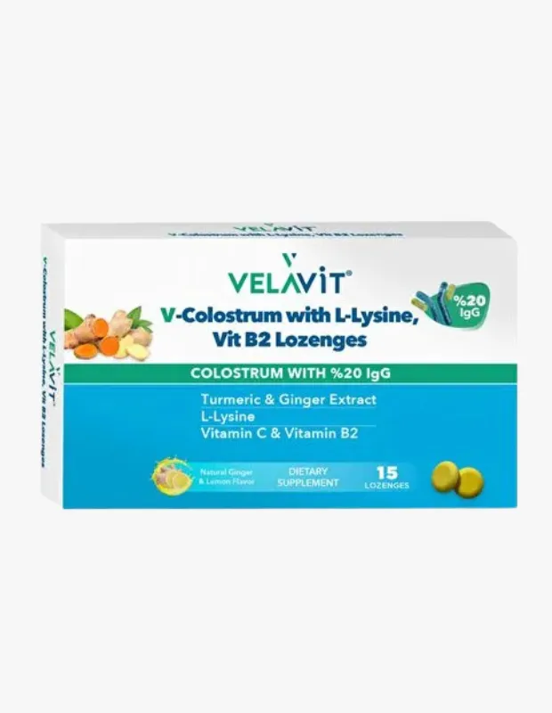 Beyaz bir kutu ambalajında sunulan, içeriğinde zerdeçal ve zencefil ekstraktı bulunan Velavit V-Colostrum L-Lizin Vit B2 pastil takviyesi, 15 adet pastil içererek genel wellness ve bağışıklık sistemine destek için tasarlanmıştır.