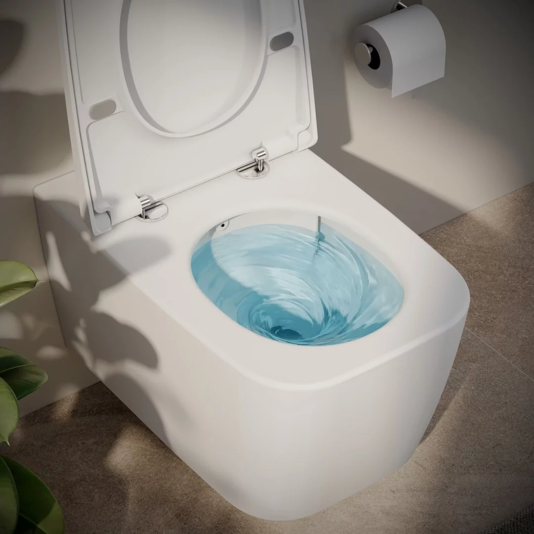 Kapağı açık duran modern, duvara monte beyaz VitrA klozetin içindeki QuantumFlush teknolojisiyle oluşan dairesel su hareketini ve arka planda duvardaki tuvalet kağıdı rulosunu net bir şekilde gösteren banyo görüntüsü.