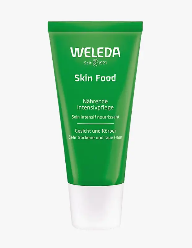 Parlak yeşil renkteki beyaz kapaklı Weleda Skin Food nemlendirici krem tüpü, markasının yanı sıra 1921'den beri var olduğunu, yoğun bakım sağladığını ve yüz ile vücuttaki çok kuru, pürüzlü ciltler için özel olarak tasarlandığını gösteriyor.