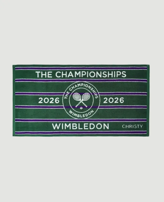 Wimbledon turnuvasının simgesel yeşil ve mor renklerini taşıyan, üzerinde ortasında ikonik tenis raketleri ve top logosu ile The Championships 2026 yazısının bulunduğu, zarif çizgili şampiyona havlusu, İngiliz yazının en prestijli tenis ritüelini yansıtan özel bir parça.
