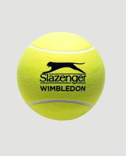 Parlak sarı renkli, üzerinde siyah Slazenger logosu ve altında WIMBLEDON yazısı bulunan, İngiliz yazının en zarif ritüellerinden biri olan prestijli Wimbledon tenis turnuvasının resmi tenis topu, bu eşsiz spor ve yaşam tarzı etkinliğinin ikonik bir sembolü olarak sade bir arka plan üzerinde dikkat çekiyor.