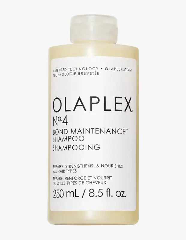 Beyaz bir arka plan üzerinde, OLAPLEX N°4 BOND MAINTENANCE SHAMPOO yazılı beyaz etiketli, şeffaf kapaklı ve açık krem rengi içeriğe sahip 250 ml'lik bir Olaplex No. 4 Bond Maintenance şampuan şişesi yakın çekim olarak gösteriliyor.
