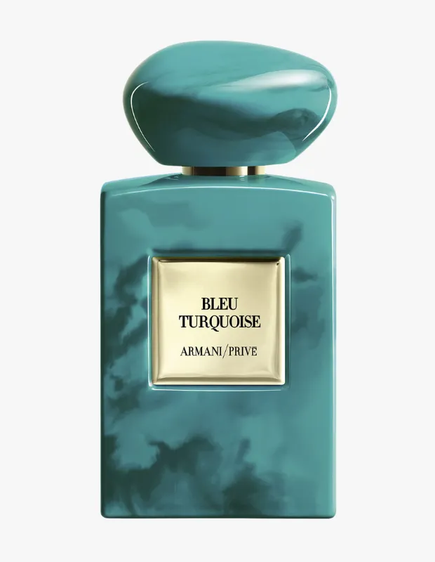 Turkuaz ve deniz yeşili tonlarında mermer desenli, dikdörtgen şekilli, zarif Armani/Prive Bleu Turquoise gelin parfümleri pürüzsüz oval kapağı ve altın rengi, kabartmalı etiketiyle dikkat çekerek beyaz bir zeminde şık bir kompozisyon oluşturuyor.