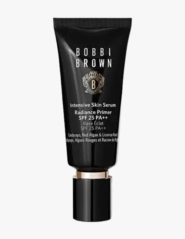 Beyaz arka plan üzerinde duran, altın detaylı siyah ambalajındaki Bobbi Brown Intensive Skin Serum Radiance Primer SPF 25 PA++ adlı makyaj bazı, cilde ışıltı veren serum bazlı bir astar olarak güneş koruması da sağlamaktadır.