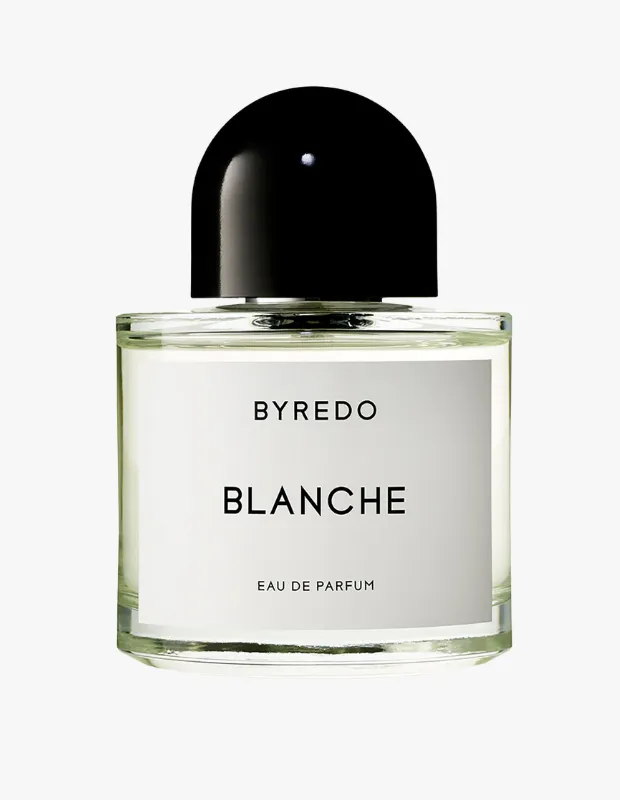 Beyaz bir arka plan önünde, şık ve minimalist bir tasarıma sahip, üzerinde belirgin BYREDO markası ve BLANCHE EAU DE PARFUM ibaresi bulunan beyaz etiketli, şeffaf camdan yapılmış dikdörtgen bir gelin parfümleri şişesi, üst kısmında siyah, kubbe şeklinde parlak bir kapağa sahiptir.
