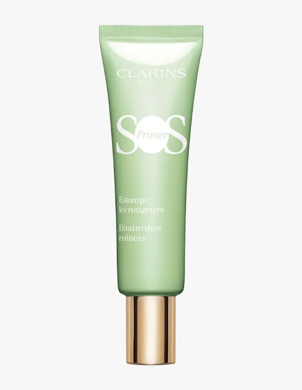 Beyaz bir zeminde dikey olarak duran, üzerinde Clarins Paris logosu, büyük harflerle SOS Primer yazısı ve Fransızca ile İngilizce olarak kızarıklığı azaltır ifadesi bulunan, alt kısmında parlak altın rengi metalik bir kapak detayı olan açık yeşil renkli Clarins SOS Primer tüpü.